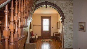 A wooden staircase with a handrail, a door with a window, and a patterned wallpaper wall. - Welcome Hall 5 bedroom 1880’s home on 55 acres (Paris)