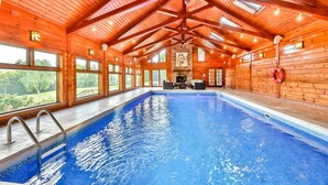 En inomhuspool med väggar av trä och ett välvt tak.