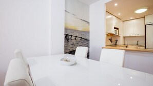 A modern kitchen with white cabinets, a wooden countertop, and a large mirror. - GO2TENERIFE Apart'Tera Solarium, Terraces, Swimming pools & Parking (Adeje)