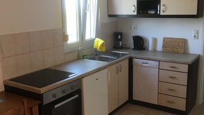 Uma cozinha compacta com fogão, forno, pia e armários.
