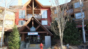 Puinen rakennus, jossa on kyltti, joka osoittaa markkinapaikan ja RE/MAX-myymälän sijainnin.