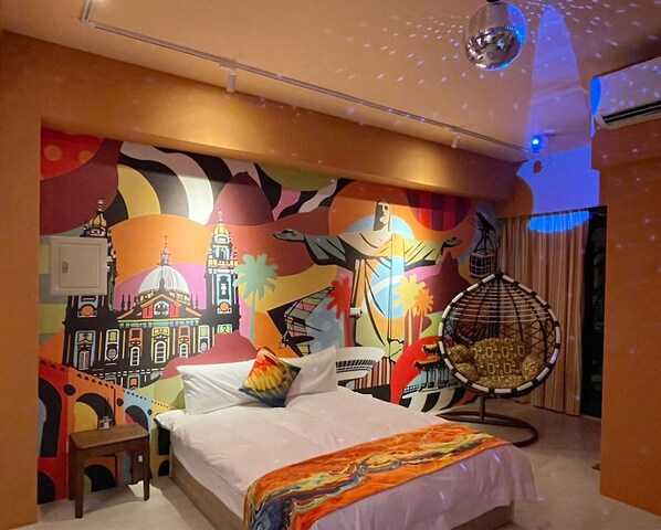 A hotel room with a bed, a chair, and a mural on the wall.