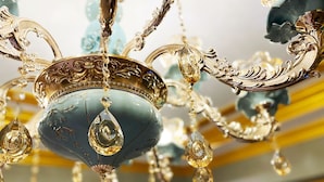 Un candelabro con diseños intrincados y múltiples elementos de cristal colgantes.