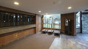 A reception area with a marble counter, a seating area with benches, and a stone wall.