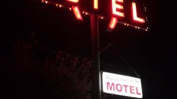 A neon motel sign with the word "MOTEL" in red letters, mounted on a pole.