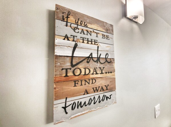 Un letrero de madera con texto motivacional en una pared.