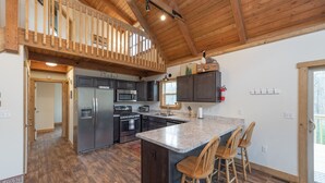 A spacious kitchen with a large island, dark wooden cabinets, and a wooden ceiling. - Cozy Mountain Retreat w/ Hot Tub & Fire Pit (Swanton)