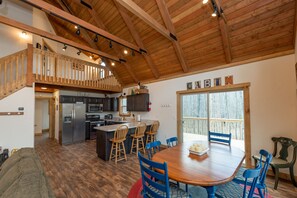 Una cocina amplia con una isla central, una mesa de comedor de madera y sillas.