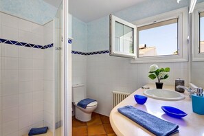 Ein Badezimmer mit Dusche, Toilette und Waschbecken.