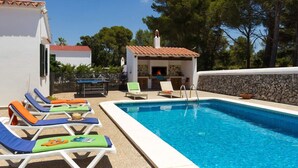 A swimming pool with lounge chairs and a small building with a tiled roof. - Ca'n Toni 3 bedroom villa, Cala Galdana (Cala Galdana)