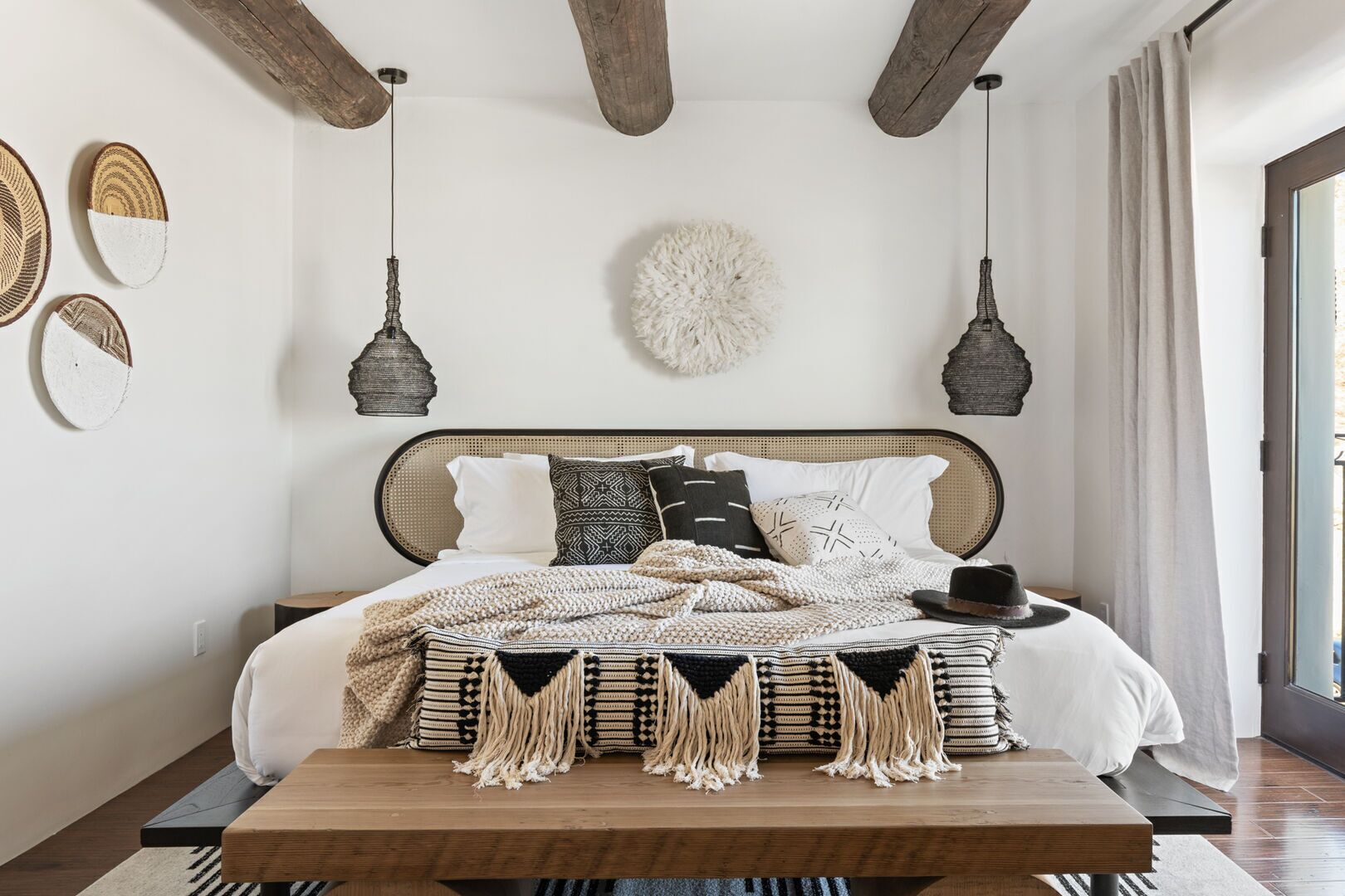 A bedroom with a bed, a wooden coffee table, and a large fluffy rug.