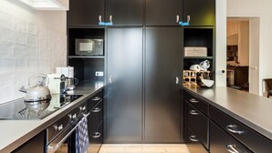 A modern kitchen with a stainless steel refrigerator, microwave, and gas stove.