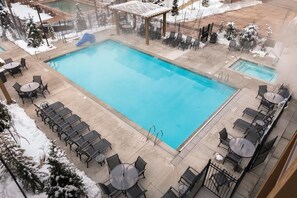 Relax by the pool surrounded by lush greenery and comfortable seating.