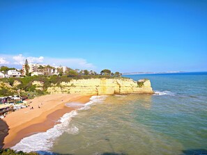 A coastal beach with a sandy shore, a cliff, and a clear blue sky. - Férias Imperdíveis , Póximo da Praia, Atrações Turisticas, bom Familias /crianç (Porches - Lagoa)