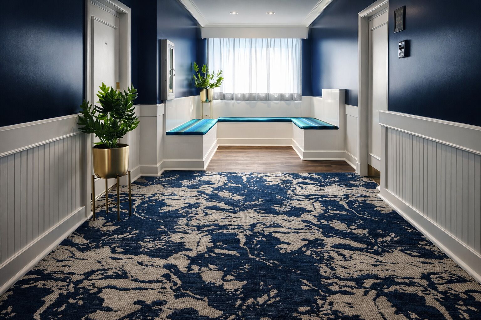A hallway with a blue patterned carpet, a bench, and potted plants.