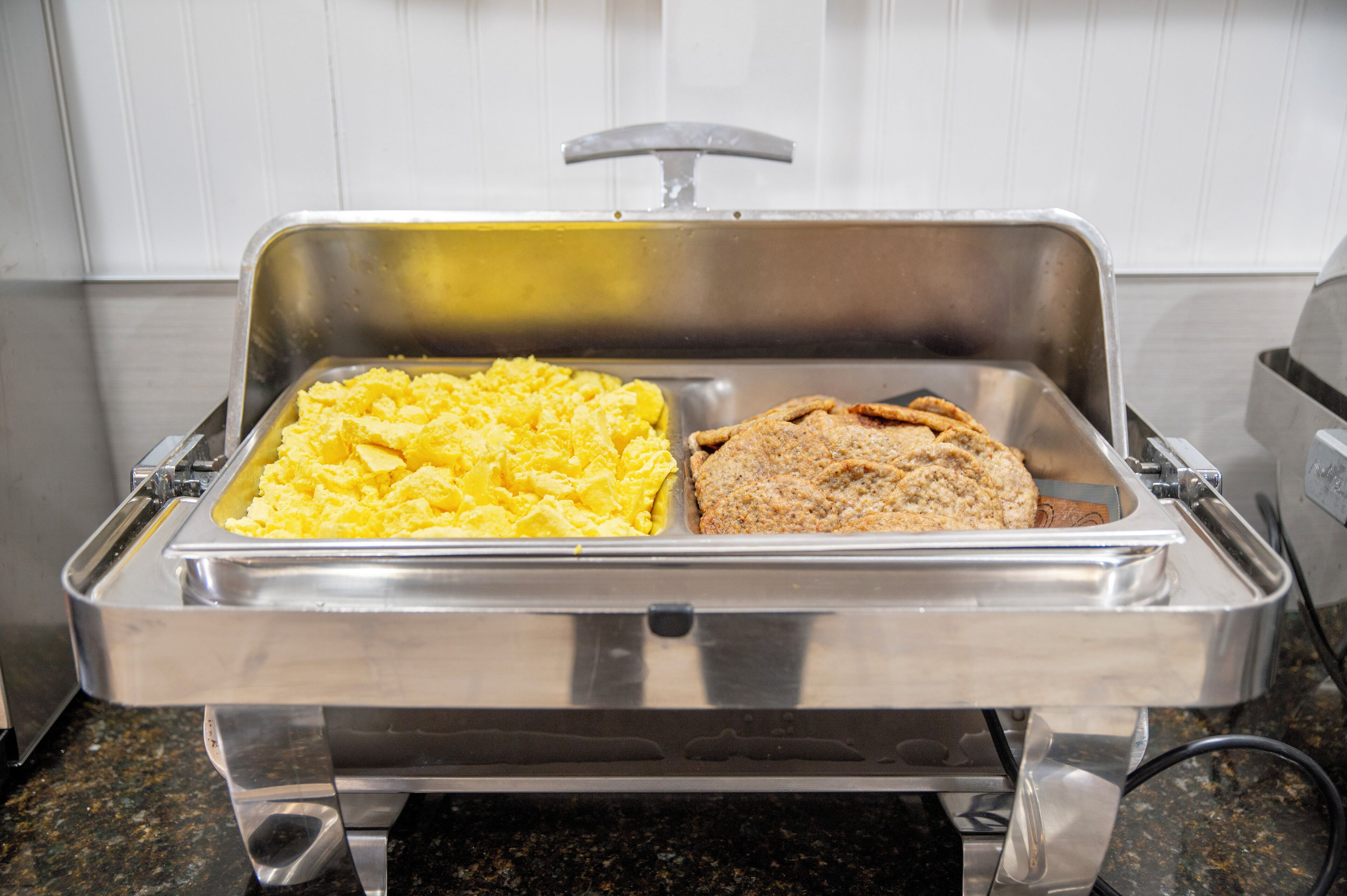 Un buffet proposant des œufs brouillés et un assortiment de pains.