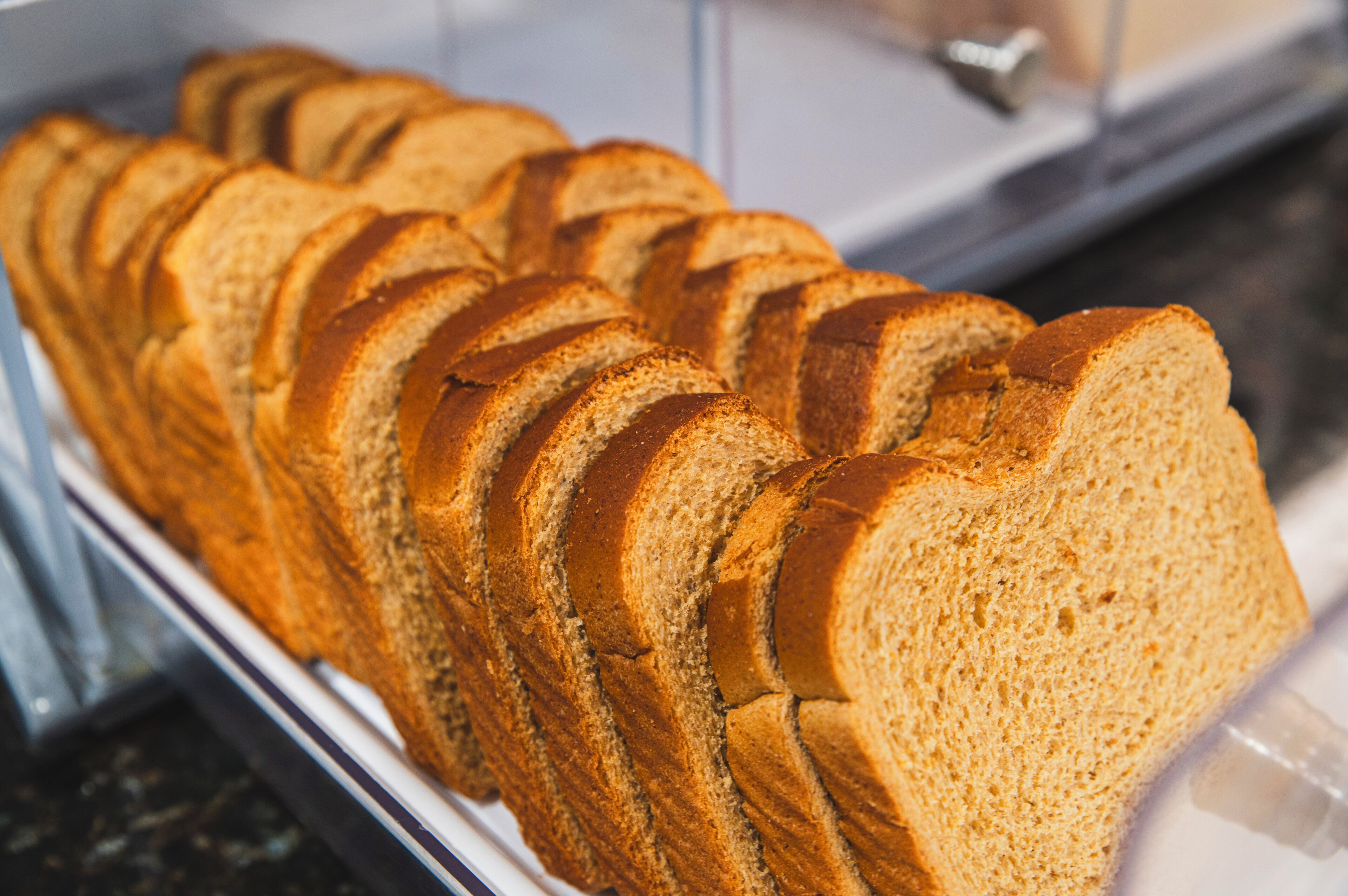 A loaf of sliced bread in a bakery display case.