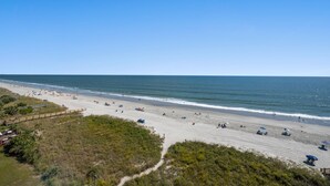 A beach with a wooden boardwalk and beach umbrellas. - Sanabel 503, 2BR 2BA Oceanfront Condo with Indoor Pool (North Myrtle Beach)