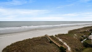 A beach with a wooden walkway leading to a building. - Sanabel 609: Oceanfront 2BR/2BA- Indoor Pool (North Myrtle Beach)