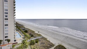 A beachfront hotel with a pool, beach access, and a view of the ocean.