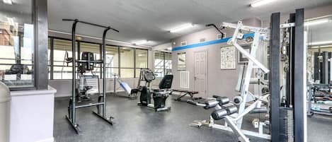 A gym with various exercise equipment, including a squat rack, bench press, and weight machines.