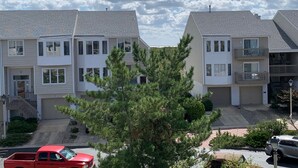 A row of two-story townhouses with a garage on the ground floor, a small front yard, and a red truck parked in the driveway. - Brigantine Beach Gem!! Rated "Exceptional" by Guests.
Top of the Line (Brigantine)