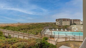 A hotel with a pool, wooden deck, and a view of the beach and ocean. - Sea Dreams: Affordable Family Friendly: Ocean Views • Pool • Linens & Amenities (Atlantic Beach)