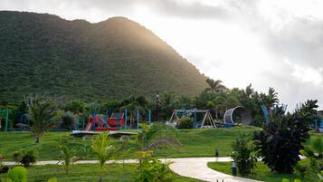Explore a family-friendly park with a large curved slide and lush green surroundings.