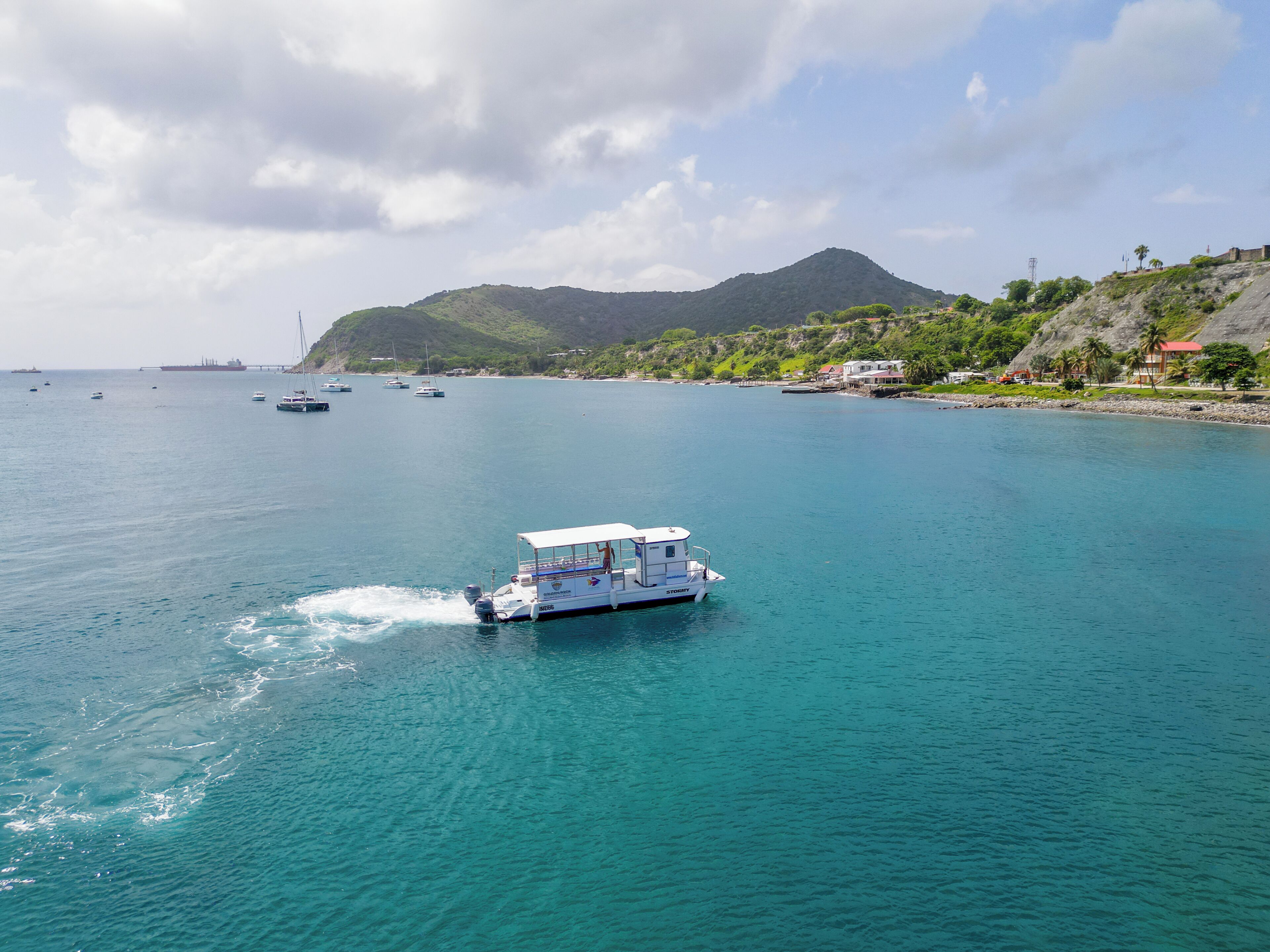 A boat on a calm sea with a mountainous landscape in the background.