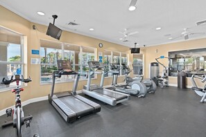 Une salle de sport équipée de tapis de course, de vélos elliptiques et de matériel de musculation.