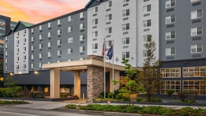 A multi-story hotel with a modern design, featuring a prominent entrance with a stone facade and a flag. - Fairfield Inn & Suites by Marriott Seattle Downtown/Seattle Center (Seattle)