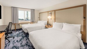 A hotel room with two beds, a desk, a chair, a nightstand with a lamp, and a window with curtains. - Fairfield Inn & Suites by Marriott Seattle Downtown/Seattle Center (Seattle)