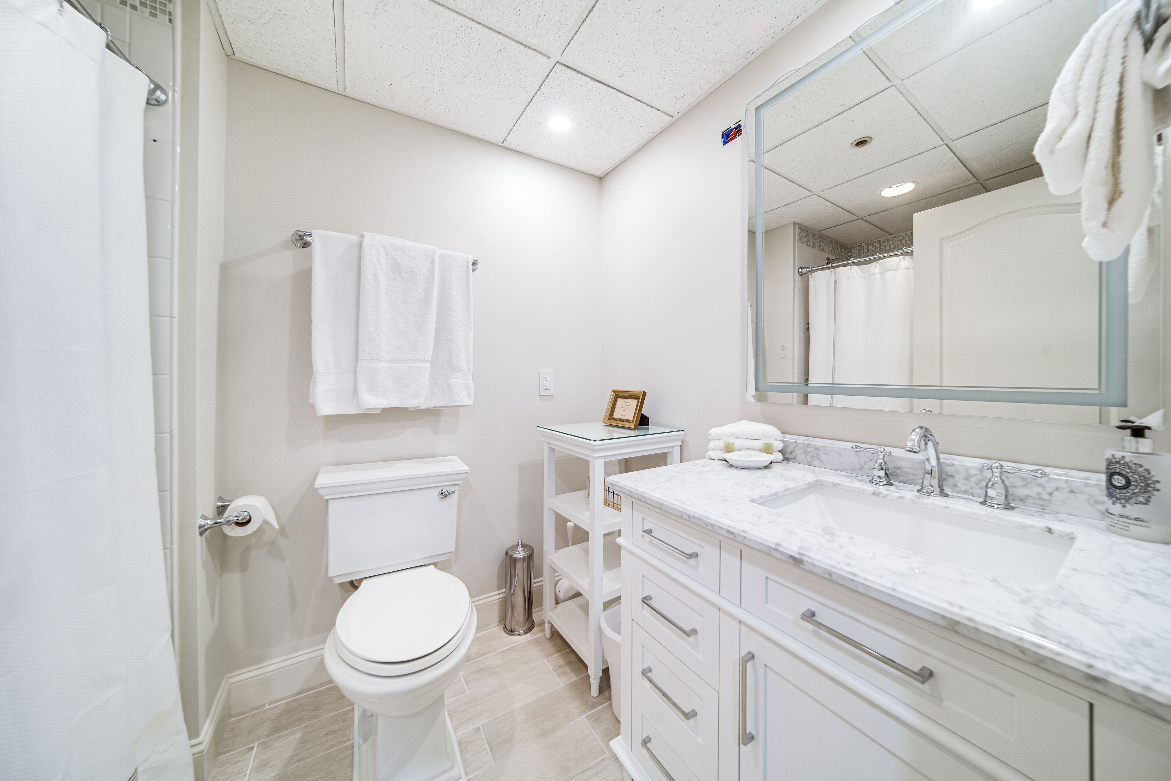 Ein modernes Badezimmer mit Toilette, Waschbecken und Spiegel.