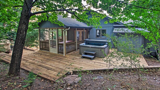 A wooden deck with a hot tub, a covered patio, and a house with a dark exterior. - Massanutten Resort Home w/ Deck + Mountain Views! (McGaheysville)