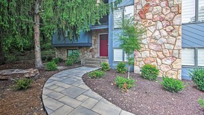 A house with a stone facade, a red door, and a stone pathway leading to the entrance. - Massanutten Resort Home w/ Deck + Mountain Views! (McGaheysville)