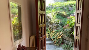 A room with a wooden door leading to a garden. - Amazing Lake Views from Large Terrace.  Swimming and Boat Dock on Property (NESSO)