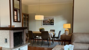 A living room with a fireplace, a dining area, and a sofa. - Amazing Lake Views from Large Terrace.  Swimming and Boat Dock on Property (NESSO)