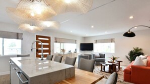A modern living space with a kitchen island, dining area, and seating. - Luxury Cardiff By-the-sea Ocean View Parkhouse (Cardiff-by-the-Sea)