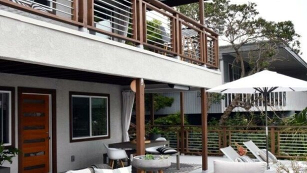 A modern outdoor living space with wicker furniture, a fire pit, and a balcony. - Luxury Cardiff By-the-sea Ocean View Parkhouse (Cardiff-by-the-Sea)