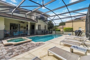 A covered outdoor swimming pool with lounge chairs, a hot tub, and a patio area. - Luxurious 5BR Villa Your Disney Getaway (Kissimmee)