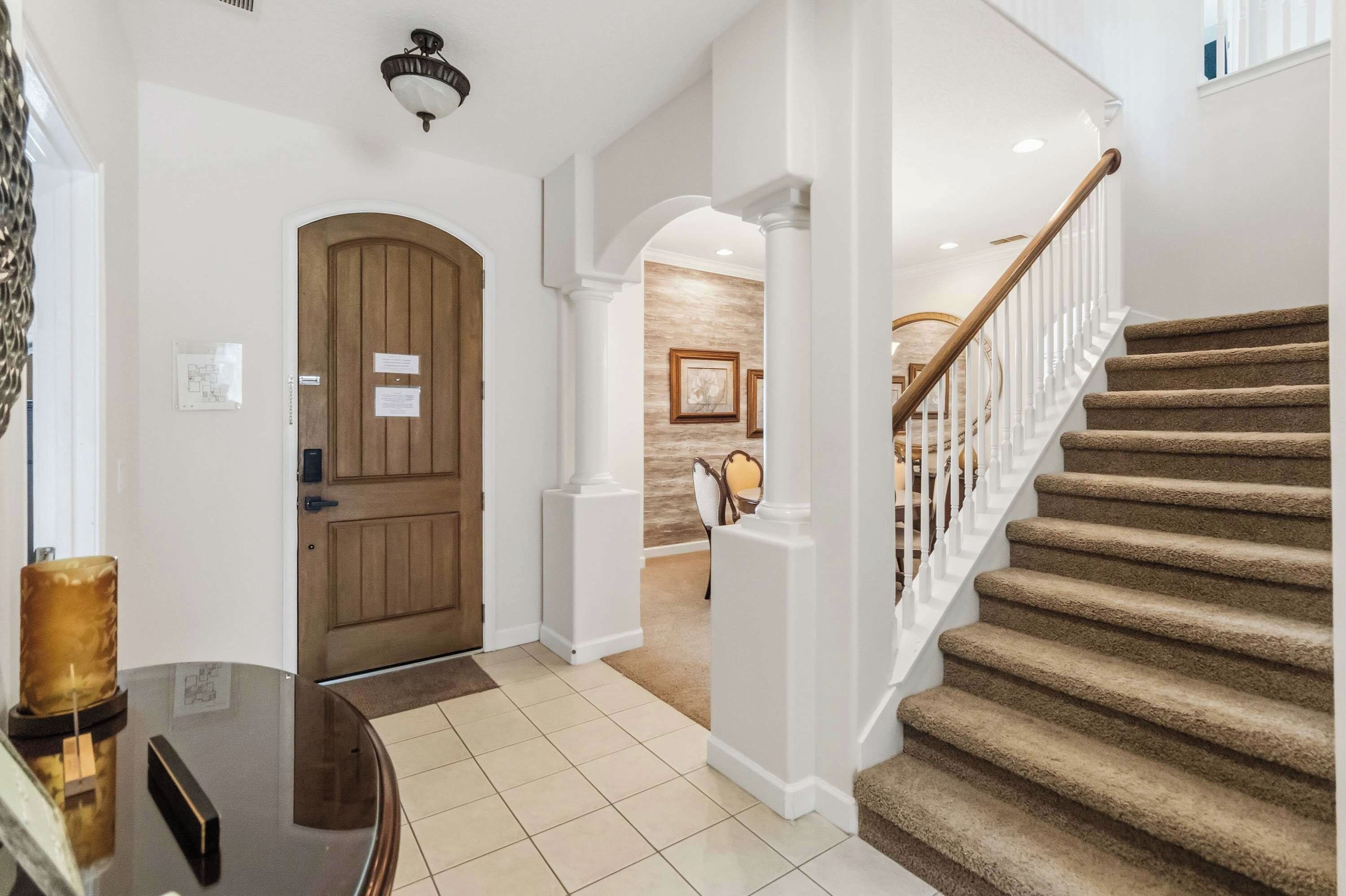 A staircase with a wooden handrail and beige carpeted steps leading to a landing.