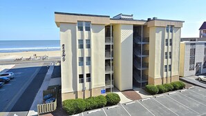 Un hotel de varios pisos con vista a la playa, estacionamiento y un letrero que dice "REGENCY".