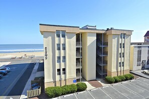 Un hotel de varios pisos con vista a la playa, estacionamiento y un letrero que dice "REGENCY".