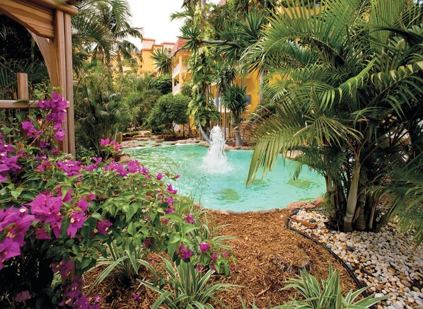 A serene garden with a central water feature, lush greenery, and a wooden pergola.