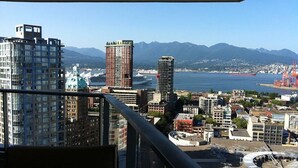 A cityscape with high-rise buildings, a marina, and mountains in the background. - 3 bedroom Downtown Vancouver S.Penthouse, near skytrain, shopping & restaurants. (Vancouver)