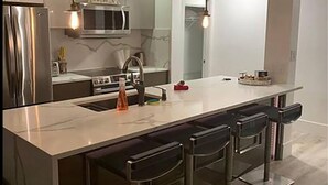 A modern kitchen with a central island, stainless steel appliances, and pendant lighting. - 3 bedroom Downtown Vancouver S.Penthouse, near skytrain, shopping & restaurants. (Vancouver)