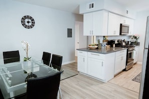 A modern kitchen with white cabinets, a microwave, and a stove. - FIFA World Cup: NEWLY RENOVATED 2-BEDROOM TOWNHOUSE WITH PRIVATE ROOFTOP DECK REMODELED IN 2022  (p30) (Los Angeles)
