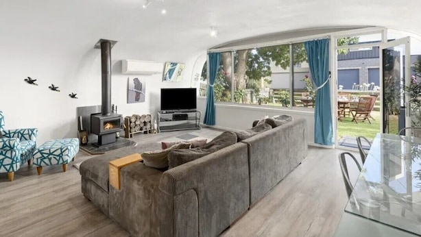 Uma sala de estar moderna com sofá, TV e lareira.