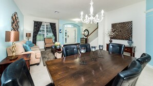 A dining area with a large wooden table, black leather chairs, and a chandelier. - Beautiful 5 Star Villa with Private Pool on the Prestigious Windsor Hills Resort, Orlando Villa 4773 (Orlando)