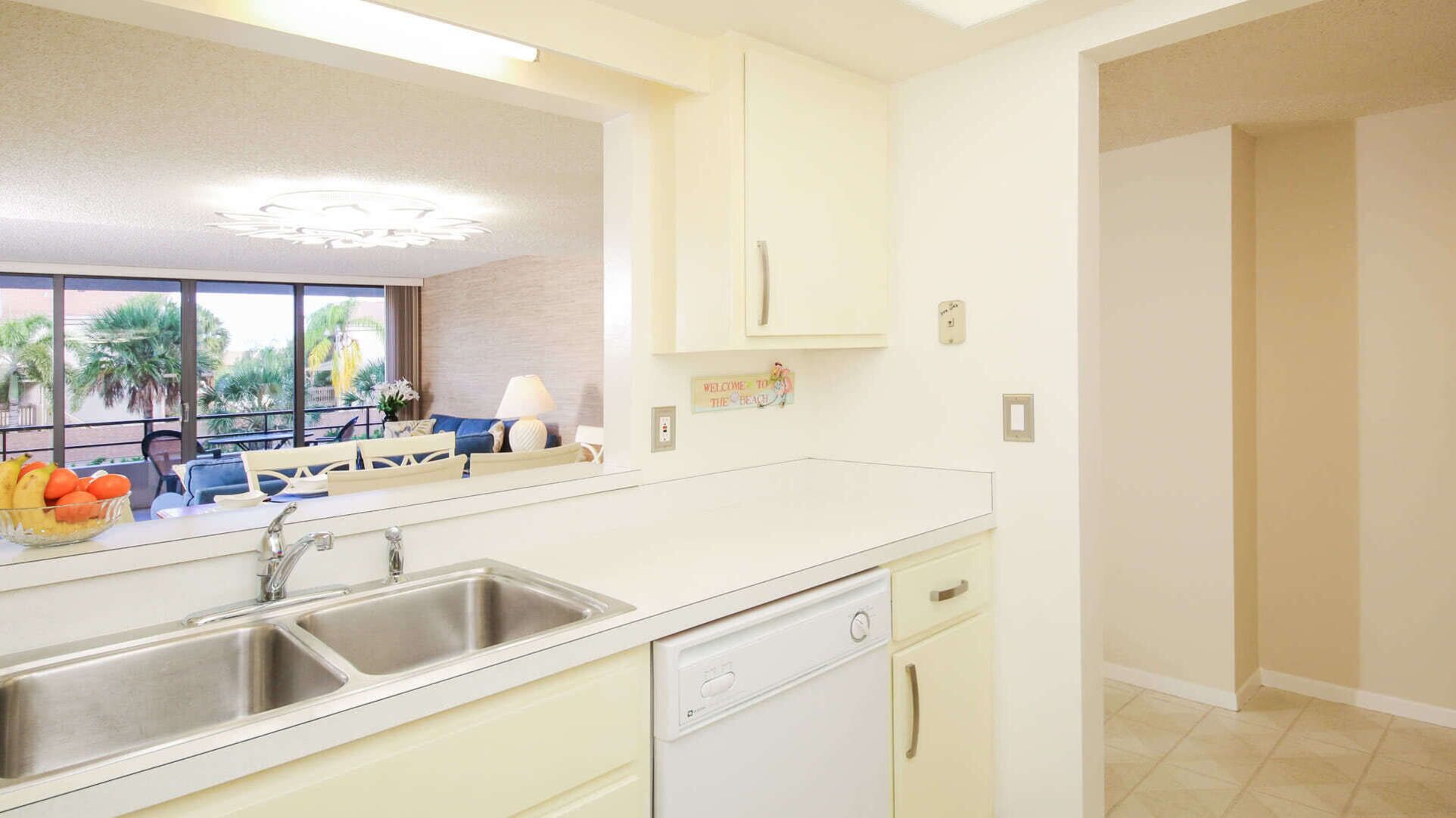 A modern kitchen with a large window, a sink, and a dishwasher.